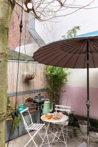 einen Tisch, zwei Stühle und einen Regenschirm in der Unterkunft Ecomama in Amsterdam