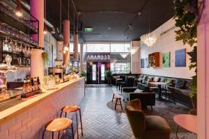un restaurant avec un bar avec des chaises et des tables dans l'établissement ClinkMama, à Amsterdam