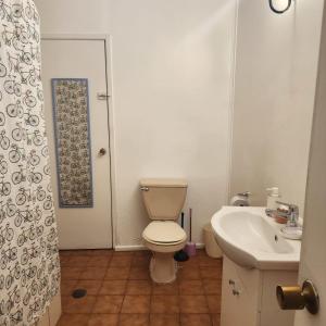 a bathroom with a toilet and a sink at Casa Portal Del Valle in La Serena +16 photos