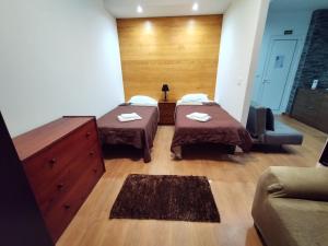 a room with two beds and a couch at Apartamentos Lisboa in Vila do Porto