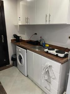 a kitchen with a sink and a washing machine at Ferienwohnung in Cecelia Resort in Hurghada