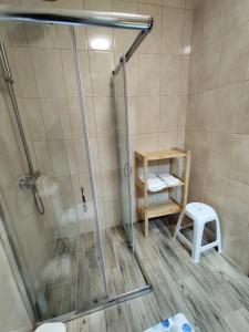 y baño con cabina de ducha y taburete. en Apartamentos Lisboa, en Vila do Porto