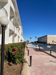 a street light next to a building with a swimming pool at Ferienwohnung in Cecelia Resort in Hurghada