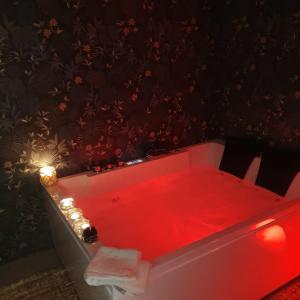una vasca da bagno rossa con pavimento rosso e luci di Mary Gery's Rooms a Castellammare del Golfo