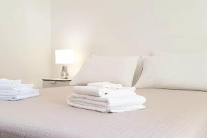 a stack of towels on a bed with a lamp at Appartamento Teatro Massimo in Catania