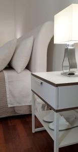 a bedroom with a bed with a table and a lamp at Appartamento Teatro Massimo in Catania +6 photos
