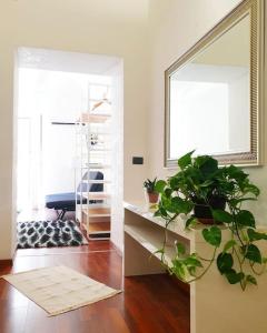a living room with a mirror and a potted plant at Appartamento Teatro Massimo in Catania