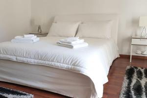 a white bed with towels on top of it at Appartamento Teatro Massimo in Catania