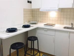 a kitchen with two frying pans on a counter with stools at Appartamento Teatro Massimo in Catania