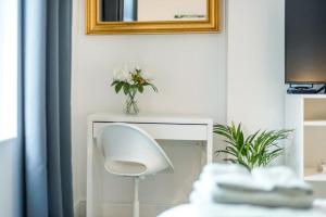 a white chair with a vase of flowers on a table at spacious flat in london in London