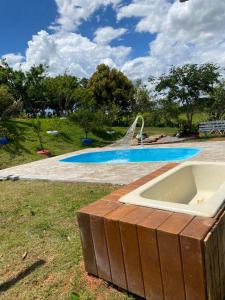 uma piscina com banheira num quintal em Recanto da Represa Carrancas em Carrancas