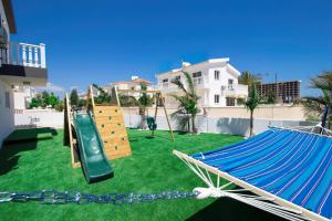 a playground with a slide and a hammock at Villa suncity Boutique Beachfront in Ayia Napa