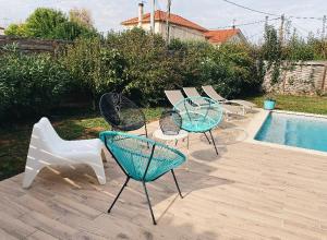 a group of chairs and tables next to a pool at Maison chaleureuse in Villeneuve-sur-Lot