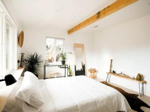 biała sypialnia z dużym białym łóżkiem w obiekcie The Zen - Outdoor Shower, Gas Fireplace, Walkable to Shops & Restaurants w mieście Joshua Tree