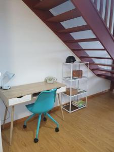 um escritório com uma secretária e uma cadeira azul em Nuevo apartamento de dos plantas em Renedo de Piélagos