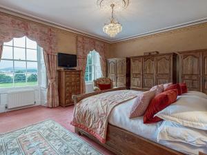 a bedroom with a large bed and a chandelier at Tal Gwynedd in Llanfairpwllgwyngyll