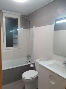 uma casa de banho com um WC, um chuveiro e um lavatório. em Nuevo apartamento de dos plantas em Renedo de Piélagos