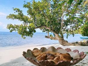 a bowl of food sitting on the beach at Biryei Homestay in Pulau Birie