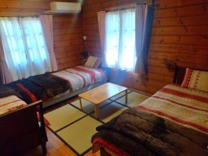 Habitación con 2 camas en una cabaña de madera en 藤のヴィラ パイン棟 Check-out11時まで! Self Check-in, en Aso