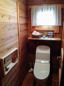 a bathroom with a toilet in a wooden cabin at 藤のヴィラ パイン棟 Check-out11時まで! Self Check-in in Aso