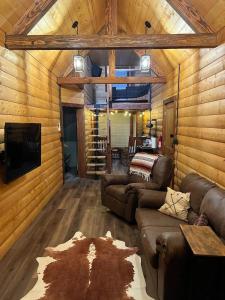 una cabina dotata di soggiorno con divani e TV. di Limestone Lodge a Sabetha