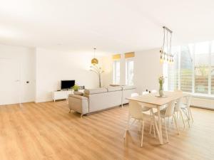 sala de estar blanca con mesa y sofá en Modern holiday home in Houthalen-Helchteren with garden, 