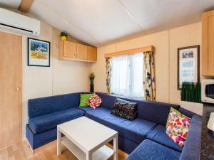 a living room with a blue couch and a table at Mobile Home in Var near Miramar Beach in La Londe-les-Maures