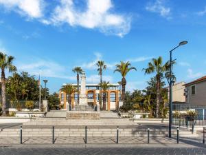 a building with palm trees in front of it at Mobile Home in Var near Miramar Beach in La Londe-les-Maures