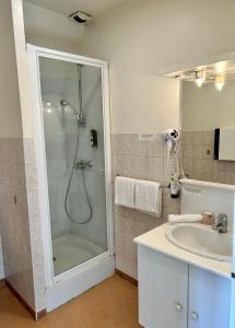 La salle de bains est pourvue d'une douche et d'un lavabo. dans l'établissement Logis Hôtel Teyssier, à Uzerche