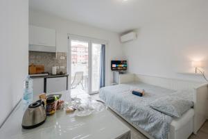 Biały pokój z łóżkiem i kuchnią w obiekcie Il Gattino di Porto - apt 4 - Monolocale terrazzo piscina w mieście Imperia +23 zdjęcia