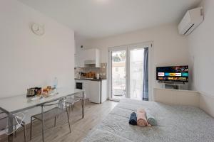 osoba leżąca na łóżku w pokoju z kuchnią w obiekcie Il Gattino di Porto - apt 4 - Monolocale terrazzo piscina w mieście Imperia
