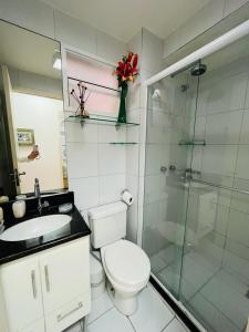 y baño con aseo y ducha acristalada. en Cond. Beach Village Residence 1 en Fortaleza
