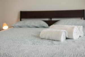 two rolled up towels sitting on a bed at Il Gattino di Porto - apt 5 - Bilocale terrazzo piscina in Imperia