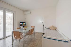 uma cozinha e sala de jantar com mesa e cadeiras em Il Gattino di Porto - apt 5 - Bilocale terrazzo piscina em Imperia