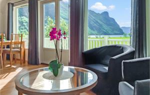 uma sala de estar com uma mesa de vidro com uma flor em Gorgeous Apartment In Dirdal With House Sea View em Dirdal