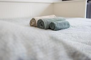 two towels sitting on top of a bed at Il Gattino di Porto - apt 6 - Monolocale terrazzo piscina in Imperia +25 photos