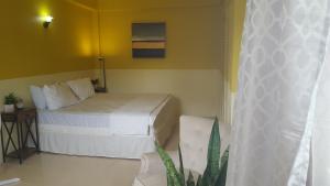 sypialnia z łóżkiem i żółtą ścianą w obiekcie bLu skAii Apt 5minutes2 Rodney Bay by car w mieście Gros Islet