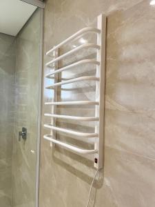 a white towel rack on the wall of a shower at Pousadinha Campos in Campos do Jordão