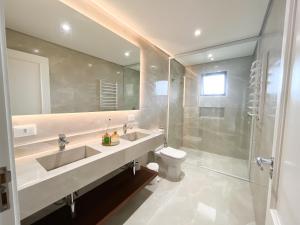 a bathroom with a sink and a shower and a toilet at Pousadinha Campos in Campos do Jordão