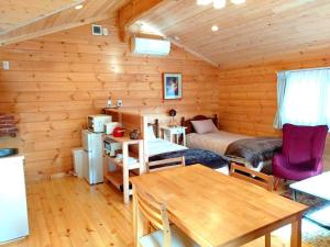 a log cabin with a bed and a table in it at 藤のヴィラ チェリー棟 Check-out 12時まで! Self Check-in in Aso