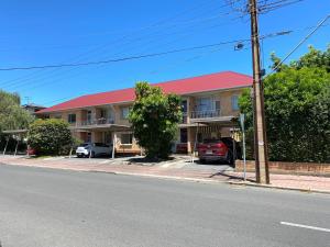 a building with a red roof on a street at Glenelg Holiday Apartments-The Broadway in Glenelg