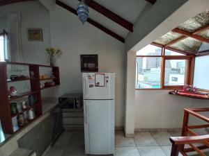 eine Küche mit einem weißen Kühlschrank im Zimmer in der Unterkunft Mini depa en centro histórico de Pueblo Libre in Lima