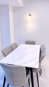 uma mesa de jantar branca com cadeiras e um candeeiro em Sunrise Gurney #CityView #GurneyDrive #FamilyStay em George Town