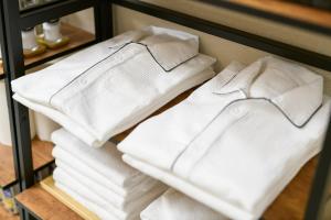 uma pilha de toalhas brancas numa prateleira em Oyado Shinmachi Gojo em Quioto