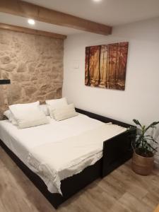 1 cama en una habitación con un cuadro en la pared en A Casiña da Ponte, en Padrón