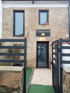 a building with a door and a sign on it at A Casiña da Ponte in Padrón