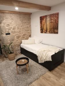 a bedroom with a bed and a table in it at A Casiña da Ponte in Padrón