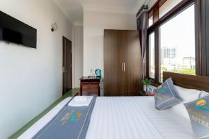 a bedroom with a bed with a large window at Tan Hoang Minh Hotel in Dong Hoi