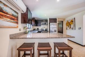 a kitchen with a counter and stools in a room at The Cove #15 in Ocotal