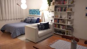 uma sala de estar com uma cama e um sofá branco em ESPAÇO AZUL Original em Curitiba